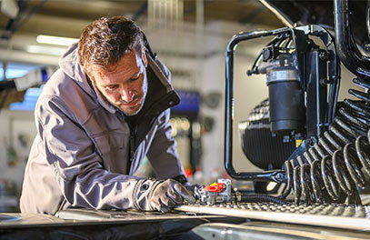 Person wartet eine industrielle Maschine in einer Produktionshalle