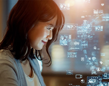 Frau betrachtet Bildschirm mit Diagrammen und Technologiegrafiken