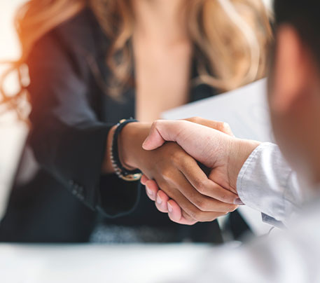 Ein Handschlag besiegelt die erfolgreiche Zusammenarbeit zwischen Unternehmen und externen Partnern im Recruiting-Prozess.