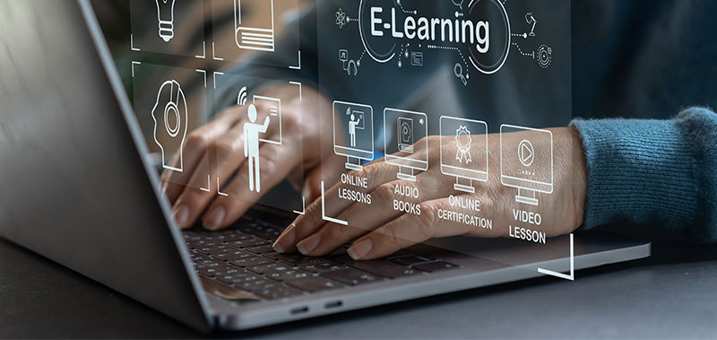 Person nutzt Laptop mit E-Learning Symbolen auf dem Bildschirm