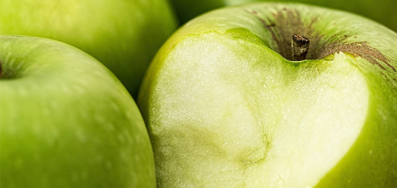 Frischer gr&uuml;ner Apfel halb angeschnitten in Nahaufnahme